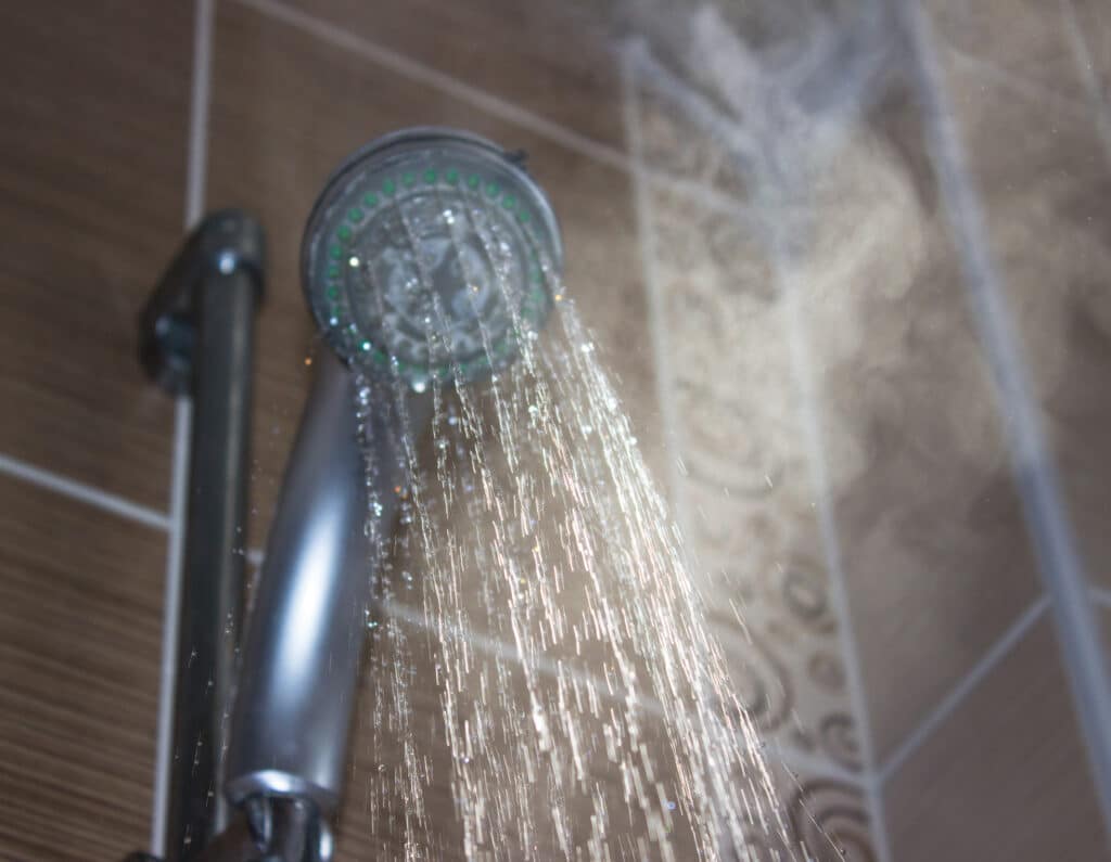 Shower head with boiling water and steam in the bathroom